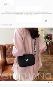Detail of black nylon crossbody bag with butterfly buckle and letter print strap