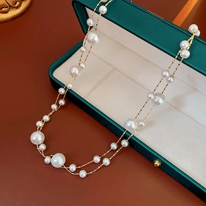 Detail of vintage gold plated double layer pearl necklace in a green jewelry box