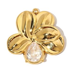Close-up of gold flower pendant featuring a large teardrop-shaped clear zircon stone