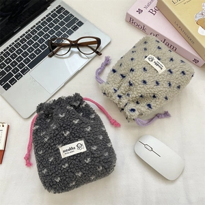 Detail of plush lamb wool drawstring pouches with heart patterns and woven labels