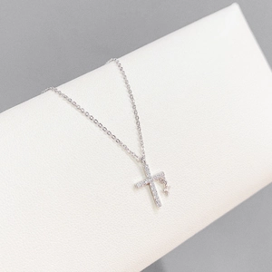 Close-up of silver necklace with double cross pendants set with sparkling zircons