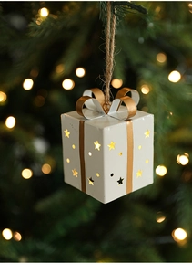 Gros plan d'un coffret cadeau lumineux avec étoiles et nœud doré sur un sapin de Noël