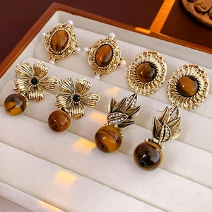 Détails de boucles d'oreilles baroques vintage avec œil de tigre et perles dans un coffret
