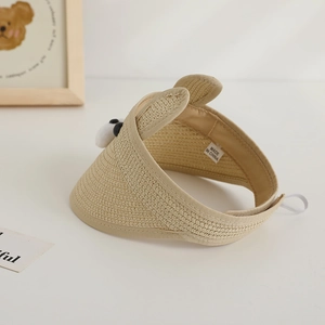 Detail of kids straw sun visor featuring a cute bear plush and elastic back strap