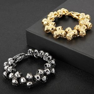 Detail of silver and gold skull link bracelets on a black jewelry box display