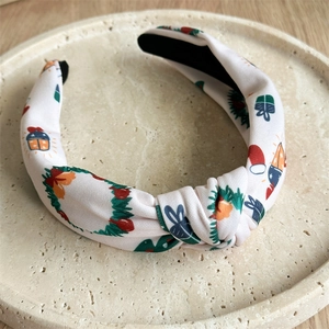 Close-up of pink Christmas headband with festive gift boxes and floral patterns