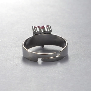 Macro shot of silver stainless steel adjustable ring featuring a pink heart gemstone