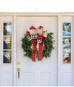 Plaid burlap Christmas bow decoration displayed on a festive wreath over a white door