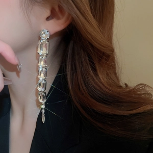 Close-up of long tassel earrings with sparkling transparent rectangular crystals