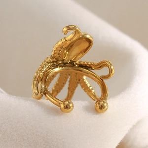 Bijou clip d'oreille pieuvre créatif pieuvre plaqué or 18 carats sur un fond en peluche blanc