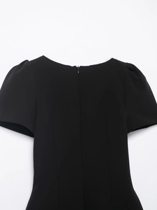 Close-up of black dress back showing bubble sleeves and detailed zipper closure