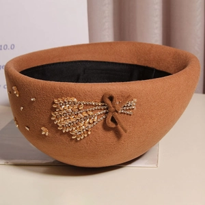 Detail of crystal wheat ear rhinestone and bow on camel wool felt beret hat