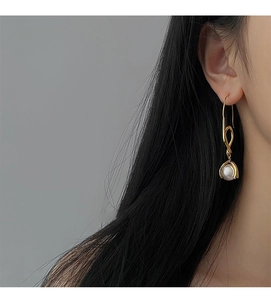 Detailansicht eines goldenen geometrischen Perlenohrrings am Modell für minimalistischen Look