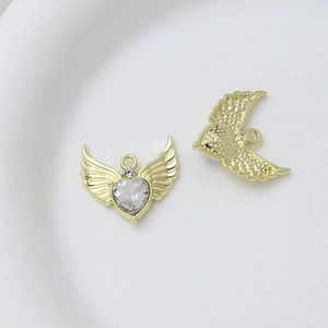Macro view of heart-shaped angel wing pendant with clear zircon and gold plating