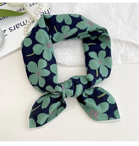 Detail showing navy cotton-linen scarf with green floral prints and white stitched edges
