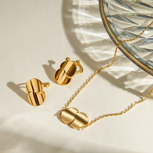 Detail view of 18k gold stainless steel jewelry set with geometric curved pendants