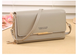 Detail view of the grey multi-functional crossbody wallet with double zipper and gold trim