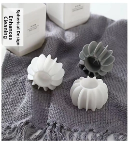 Detailed view of three anti-tangling laundry balls on a grey textured fabric background