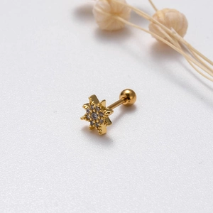 Close-up of gold star cartilage stud with cubic zirconia and ball screw back closure