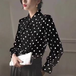 Detail of elegant bow-tie neckline and polka dot pattern on long lantern sleeves