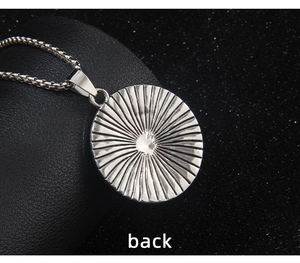 Macro view of the smooth stainless steel sunburst texture on the pendant's back