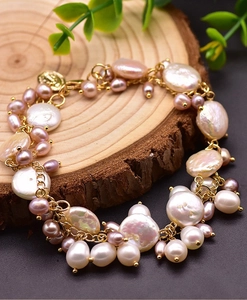 Macro shot of natural baroque pearls and gold chain links on a rustic wood background