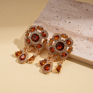 Detail of luxury vintage gold drop earrings with amber stones and sparkling crystals
