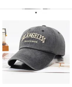 Detail of vintage washed dark gray cotton baseball cap with thick white 3D embroidery