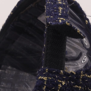 Détail d'une casquette en tweed bleu marine avec fils dorés et sangle élastique dos