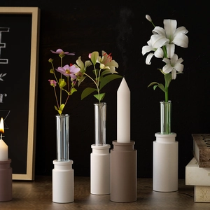 Close-up of modern geometric matte candle holders and glass vase tubes for home decor
