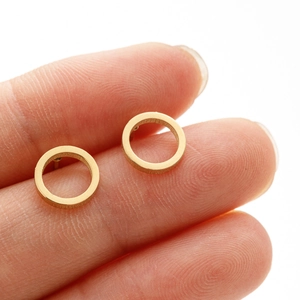 Minimalist round 18K gold stainless steel hoop earrings shown for scale on a finger