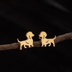 Minimalist golden dachshund dog stud earrings on dark branch background
