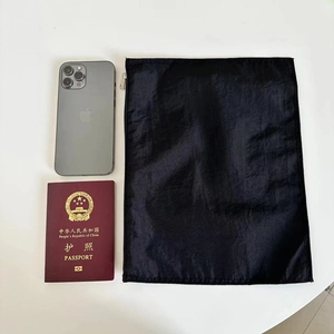 Flat nylon organizer pouch with metal zipper shown next to a phone for size comparison