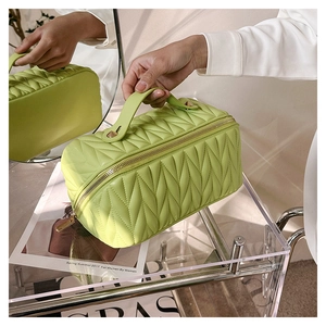 Dettaglio della borsa cosmetica in pelle PU trapuntata verde con cerniera dorata
