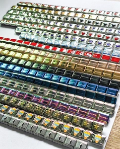 Close-up of assorted stainless steel charms and colorful enamel links for modular bracelets
