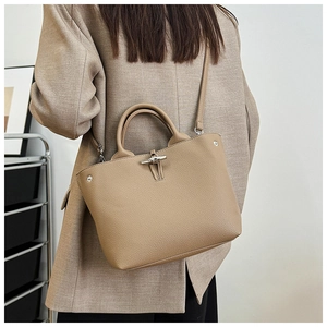 Detail of lychee pattern leather bucket bag with signature bamboo buckle and shoulder strap