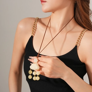 Detail of leather cord necklace with white cloud and yellow star resin pendants