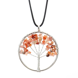 Detail of handmade wire wrapped tree of life pendant with red natural stones