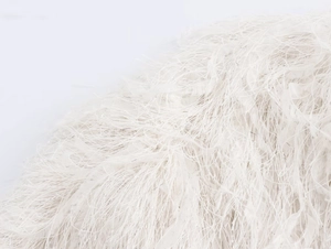 Détail d'une veste à franges blanche montrant des plumes douces et des fibres soyeuses