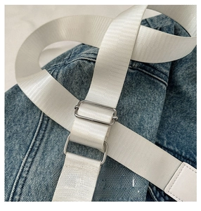 Close-up of white woven shoulder strap with adjustable silver metal buckle detail