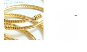 Close-up of golden twisted rope bangle featuring textured spiral design and industrial detail