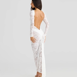 Détail de robe longue en dentelle blanche avec coupe dos nu et manches longues