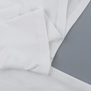 Close-up of white ribbed knit fabric texture and high-quality stitching on the sleeve cuff