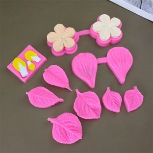 Food grade silicone molds set for fondant leaves and flowers on a dark surface