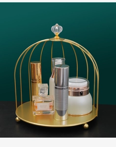 Detail of golden birdcage cosmetics rack with metallic luster and crystal handle