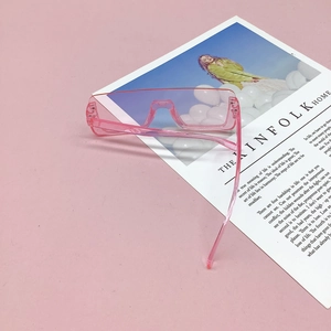 Close-up of pink oversized kids sunglasses on magazine background with square frame design