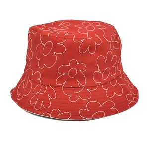 Détail d'un chapeau bob en coton rouge orné de motifs floraux brodés blancs élégants