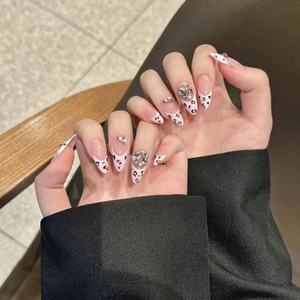 Pink leopard print press-on nails with almond shape, French tips, and heart rhinestones