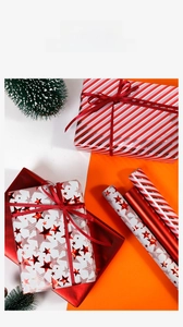 Detail of red and white striped Christmas wrapping paper with festive star patterns and ribbons