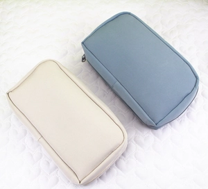 Detailed top view of beige and blue canvas pencil cases with zipper on quilted fabric